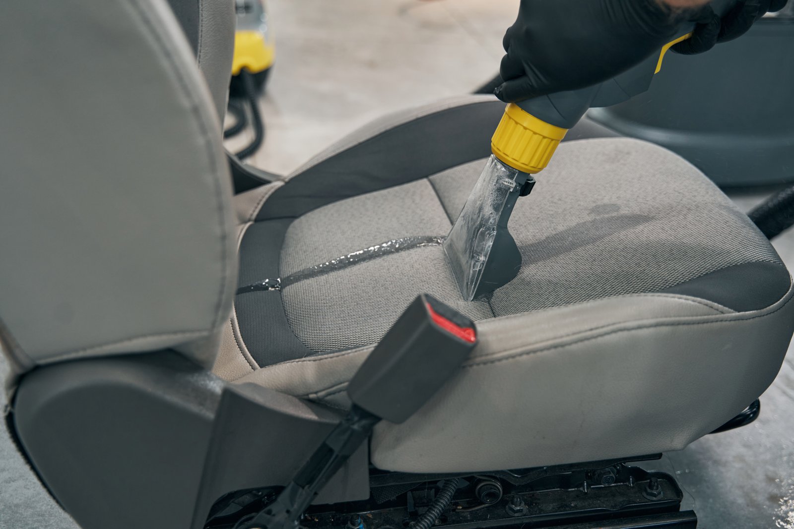 Specialist dry-cleaning removed car seat. Mechanic vacuum wash fabric